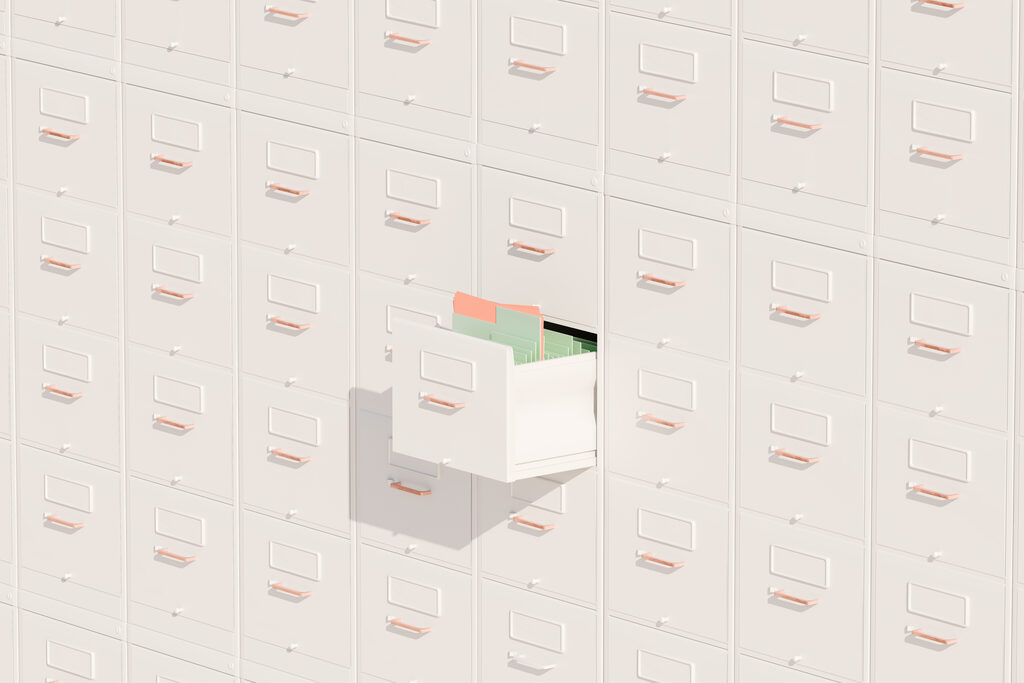 A wall of paper-white filing cabinets with one drawer pulled open, showing organized files